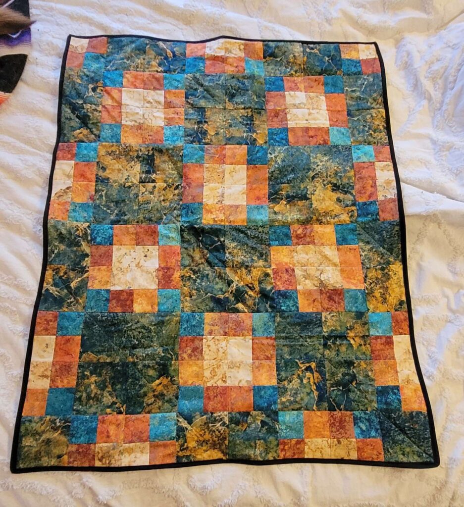 Simple quilted project made out of squares -- yellow, orange, teal, green and gold