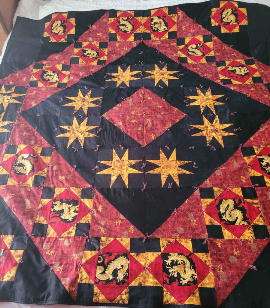 Red, black and gold quilt with dragons